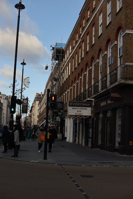 A residential street scene in Marylebone showing a paved sidewalk with a curved metal railing, behind which several bicycles are parked. The sidewalk is clean and smooth, with a few pedestrians visibl
